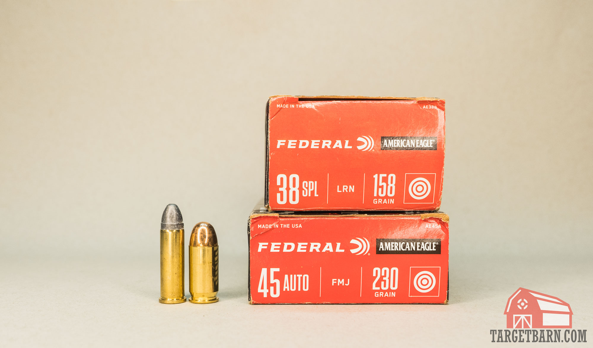 a .38 special round next to a .45 acp round and a box of federal 38 on top of a box of 45 acp